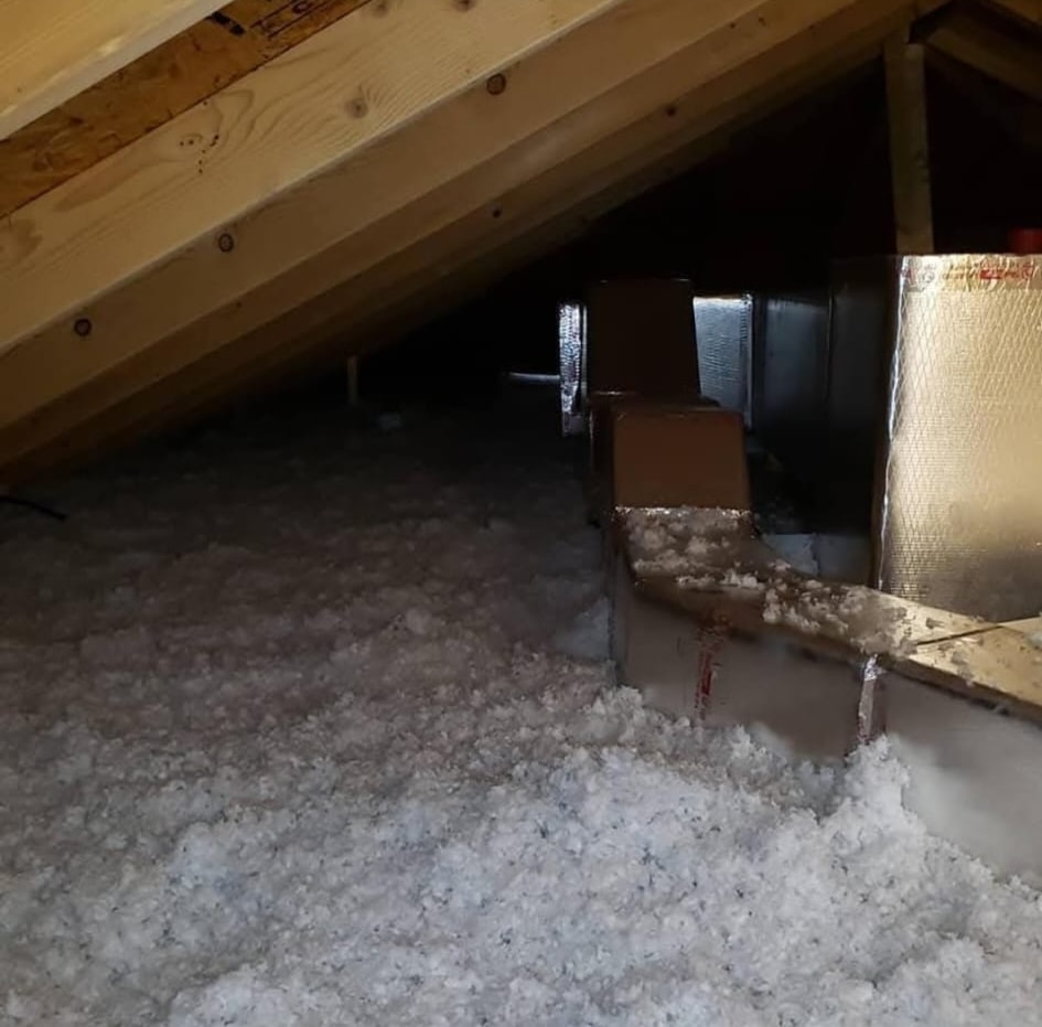 Residential attic with completed white blown-in insulation